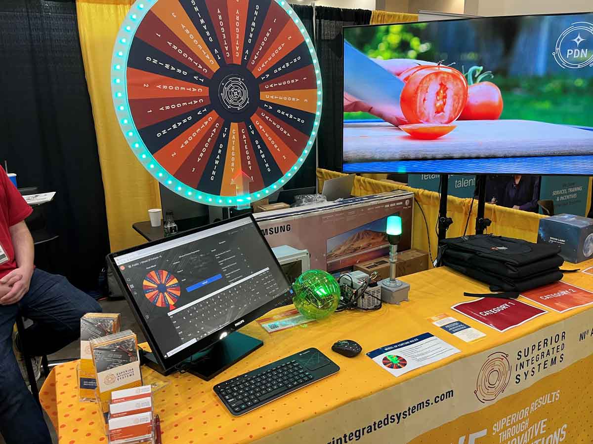 Superior Integrated Systems booth at Advance Manufacturing Expo with spinning wheel to win prize